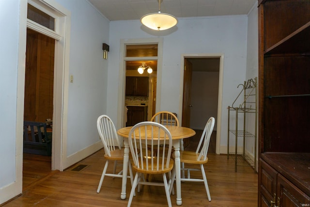 dining area featuring ornamental molding and hardwood / wood-style floors