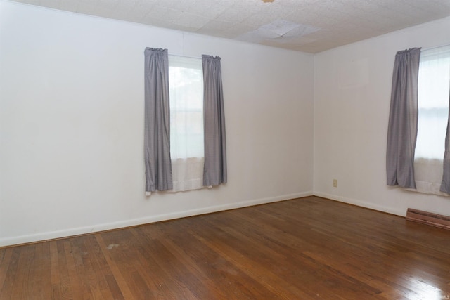 empty room with dark hardwood / wood-style flooring