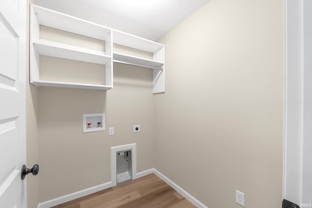 laundry room featuring hookup for an electric dryer, hookup for a washing machine, hardwood / wood-style floors, and a textured ceiling