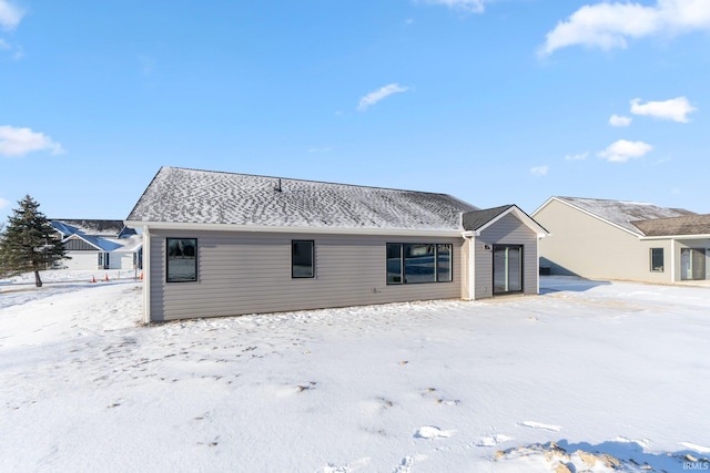 view of snow covered rear of property