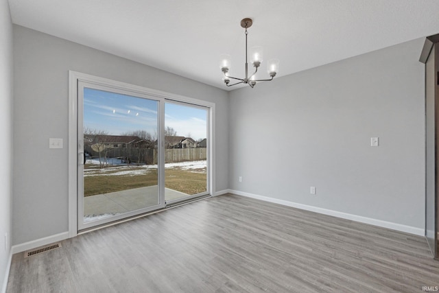 602 Zion Hill Rd, Ligonier, IN 46767 - spare room with wood finished floors, baseboards, a chandelier, and visible vents