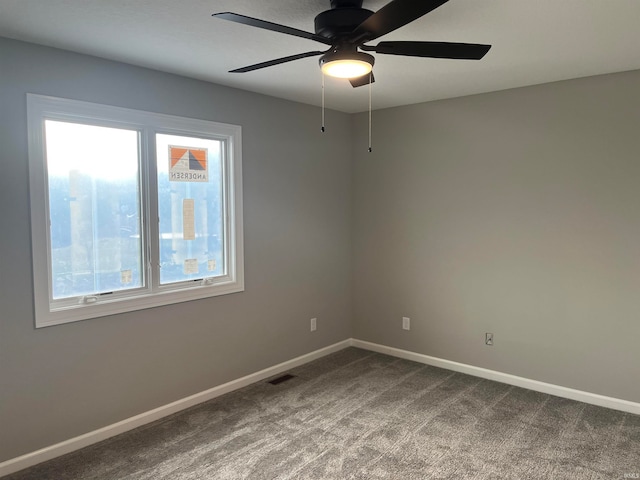 carpeted empty room with ceiling fan and a wealth of natural light