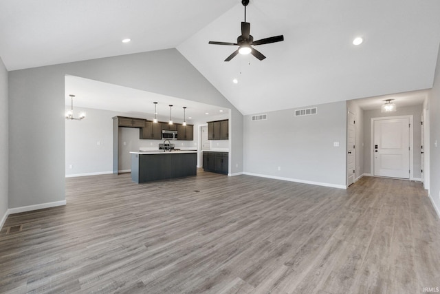 602 Zion Hill Rd, Ligonier, IN 46767 - unfurnished living room featuring ceiling fan with notable chandelier, baseboards, light wood finished floors, and visible vents