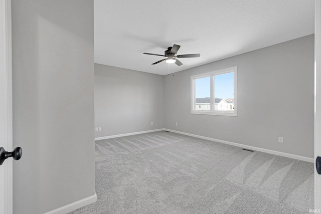 carpeted spare room featuring ceiling fan and a textured ceiling