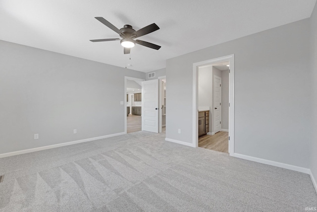 unfurnished bedroom featuring ceiling fan, connected bathroom, and light colored carpet