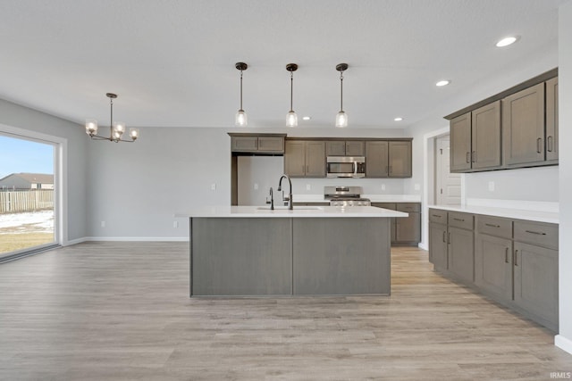 602 Zion Hill Rd, Ligonier, IN 46767 - kitchen featuring a sink, a notable chandelier, appliances with stainless steel finishes, and light wood finished floors
