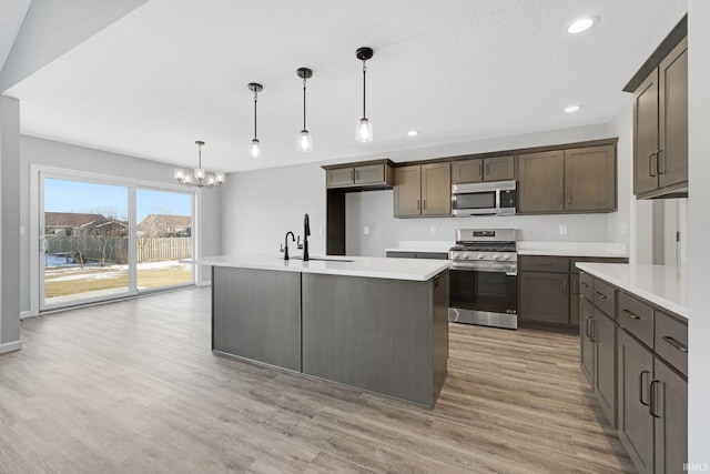 602 Zion Hill Rd, Ligonier, IN 46767 - kitchen with light countertops, a chandelier, a sink, light wood-style flooring, and appliances with stainless steel finishes