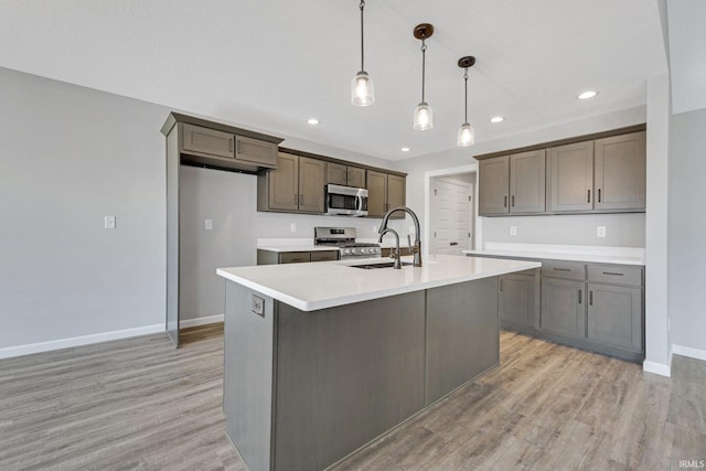 602 Zion Hill Rd, Ligonier, IN 46767 - kitchen featuring light countertops, light wood-type flooring, stainless steel appliances, baseboards, and a sink