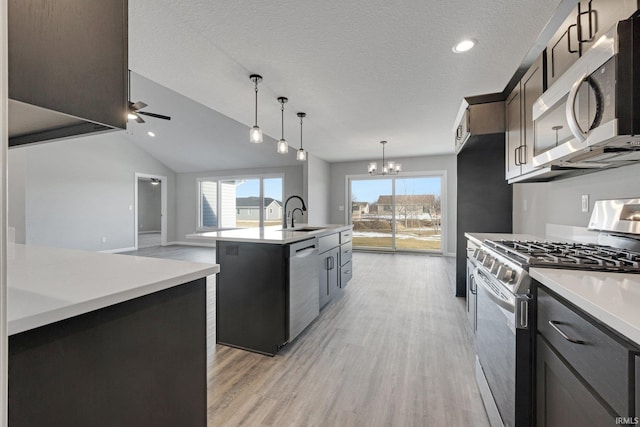 602 Zion Hill Rd, Ligonier, IN 46767 - kitchen featuring light countertops, a kitchen island with sink, stainless steel appliances, light wood-type flooring, and ceiling fan with notable chandelier