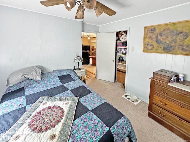 bedroom with ceiling fan, a closet, light colored carpet, and wood walls