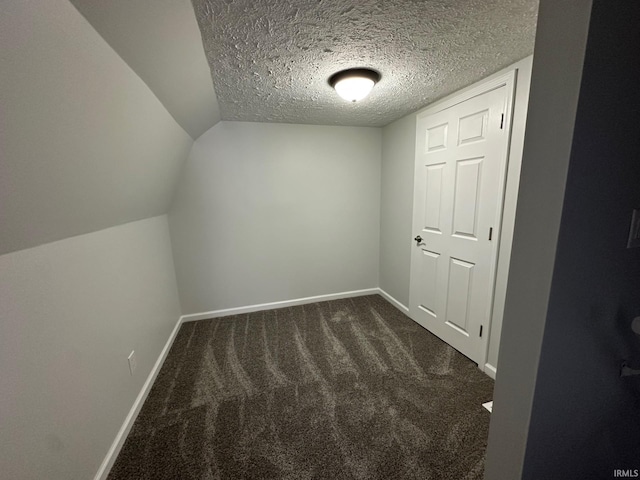 bonus room featuring dark colored carpet, a textured ceiling, and lofted ceiling