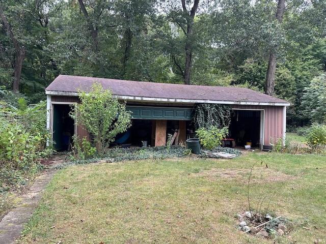 view of outdoor structure with a yard and a garage