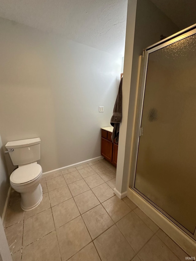 bathroom featuring tile patterned floors, vanity, toilet, and walk in shower