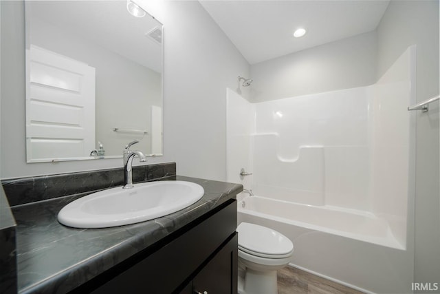 full bathroom with vanity, toilet, hardwood / wood-style flooring, and shower / bathtub combination