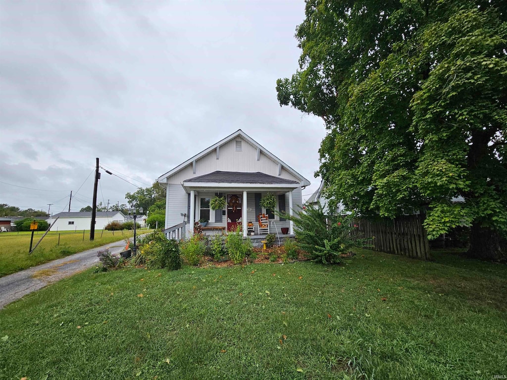 bungalow with a porch and a front lawn