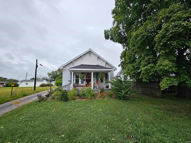 bungalow with a porch and a front lawn