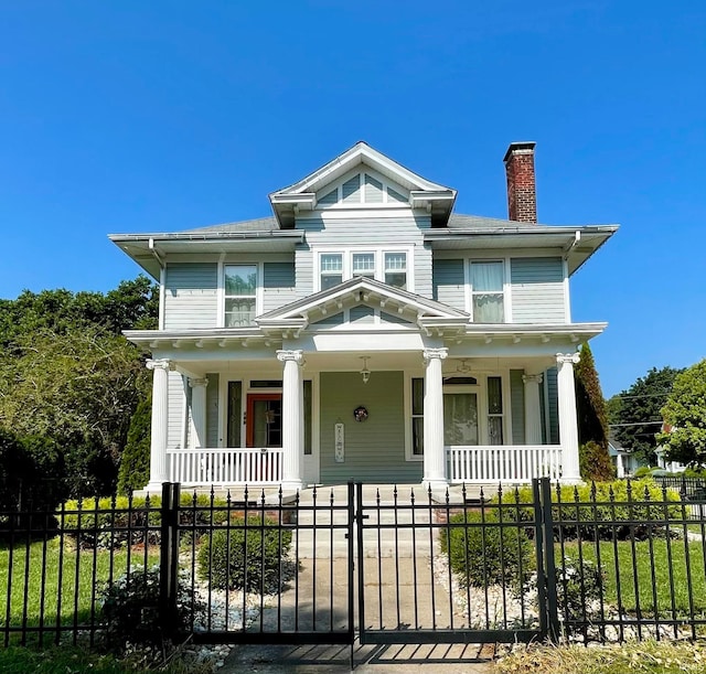 view of front of property with a fenced front yard, a gate, a porch, and a chimney