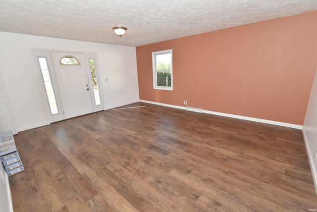 entryway featuring a textured ceiling and dark wood-type flooring