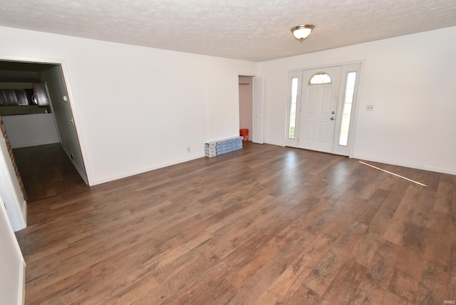 foyer entrance with a textured ceiling and dark hardwood / wood-style floors