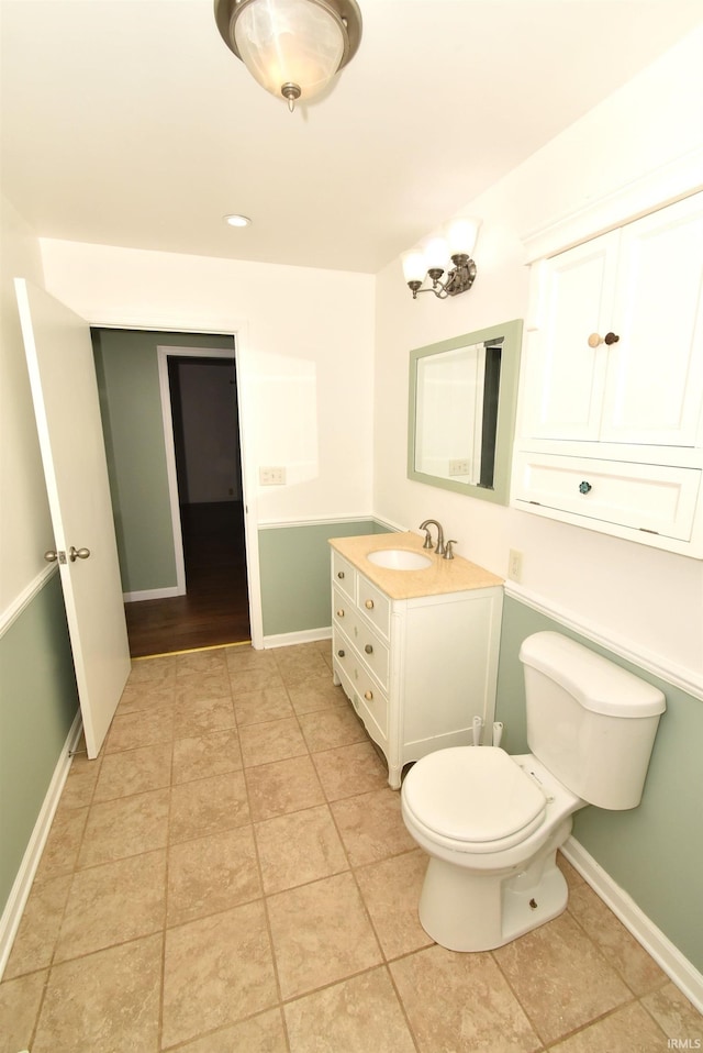 bathroom featuring tile patterned flooring, vanity, and toilet