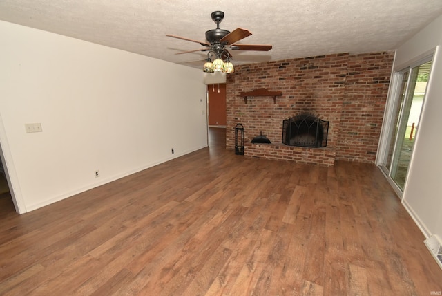 unfurnished living room featuring a textured ceiling, a fireplace, dark hardwood / wood-style floors, and ceiling fan