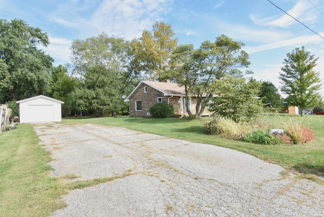 exterior space featuring a garage, a front yard, and an outbuilding