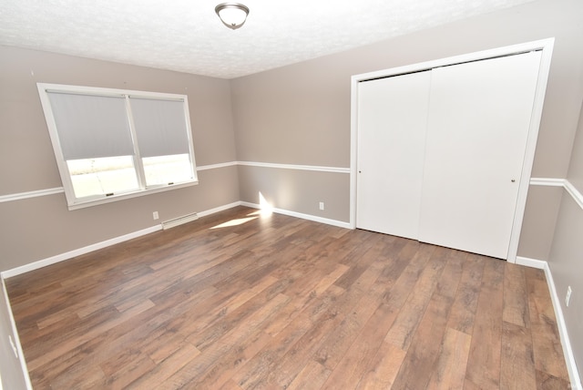 unfurnished bedroom featuring wood-type flooring and a textured ceiling