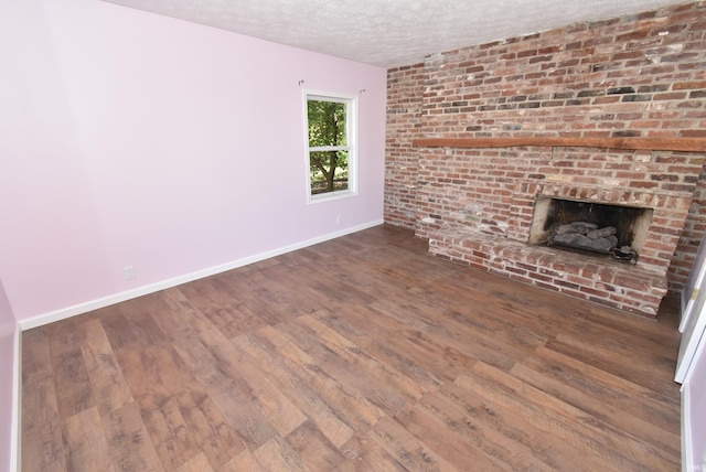 unfurnished living room with hardwood / wood-style flooring, a fireplace, and a textured ceiling