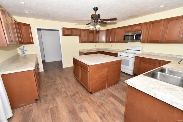 kitchen with white stove, wood-type flooring, a textured ceiling, ceiling fan, and sink