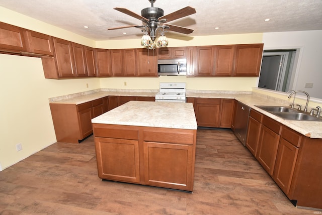 kitchen with ceiling fan, sink, kitchen peninsula, wood-type flooring, and appliances with stainless steel finishes