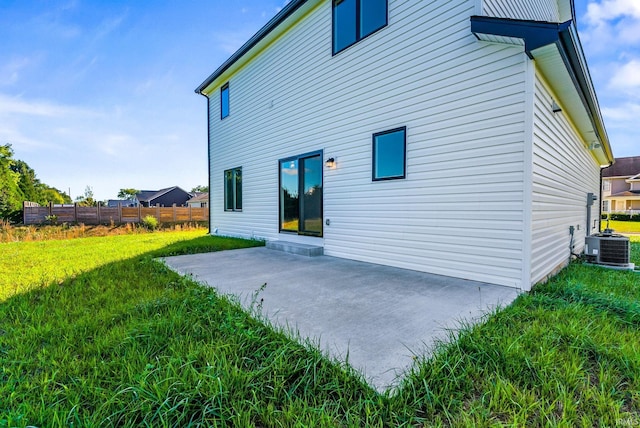 rear view of property featuring central AC, a patio area, and a yard