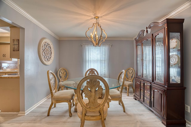 dining area featuring crown molding, a chandelier, and light hardwood / wood-style flooring