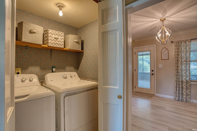 clothes washing area featuring light wood-type flooring, crown molding, an inviting chandelier, and washer and dryer