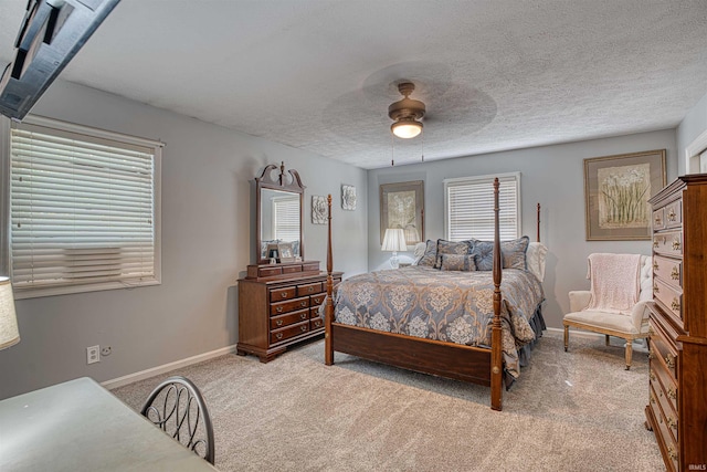 bedroom featuring multiple windows, ceiling fan, and light colored carpet