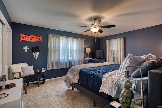 carpeted bedroom with multiple windows, ceiling fan, and a closet