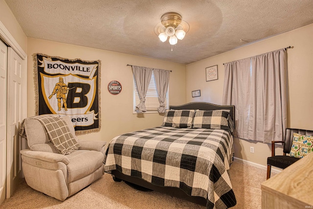 carpeted bedroom with ceiling fan, a textured ceiling, and a closet