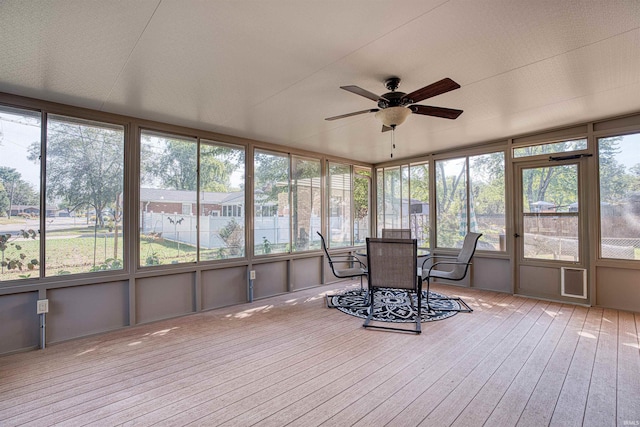 unfurnished sunroom featuring a healthy amount of sunlight, lofted ceiling, and ceiling fan