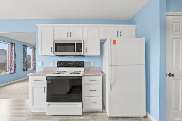 kitchen featuring light wood-type flooring, white appliances, and white cabinetry