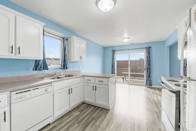 kitchen with a wealth of natural light, white appliances, and white cabinetry