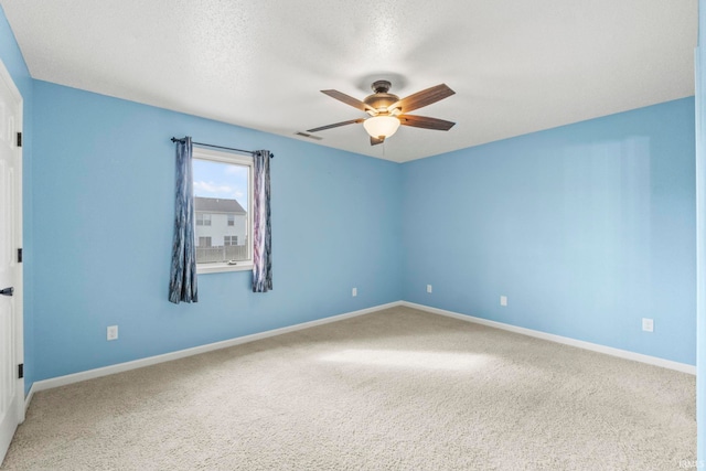 carpeted spare room with ceiling fan and a textured ceiling