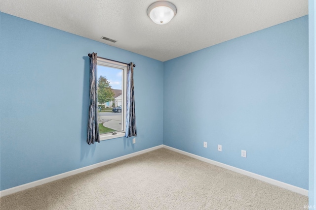 spare room with a textured ceiling and carpet