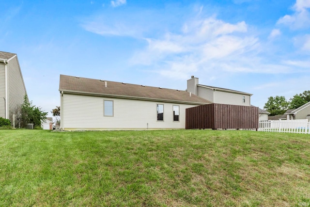 rear view of property featuring a yard