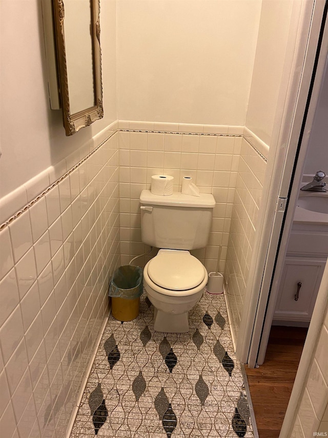 bathroom with toilet, tile walls, and tile patterned flooring