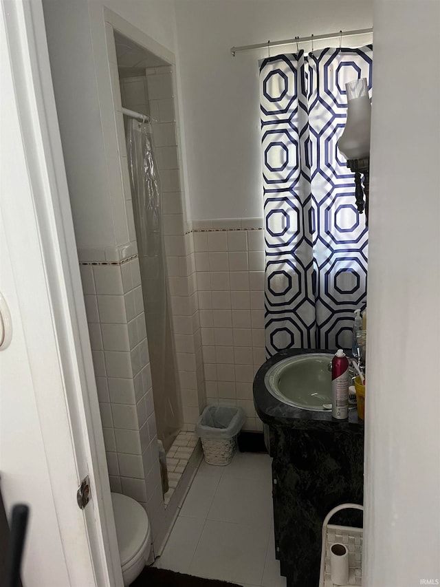 bathroom with tile patterned floors, vanity, tile walls, toilet, and a shower with shower curtain