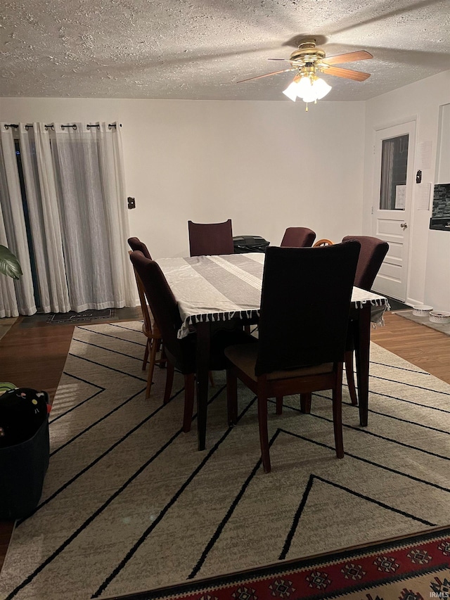 dining area featuring ceiling fan, dark hardwood / wood-style floors, and a textured ceiling