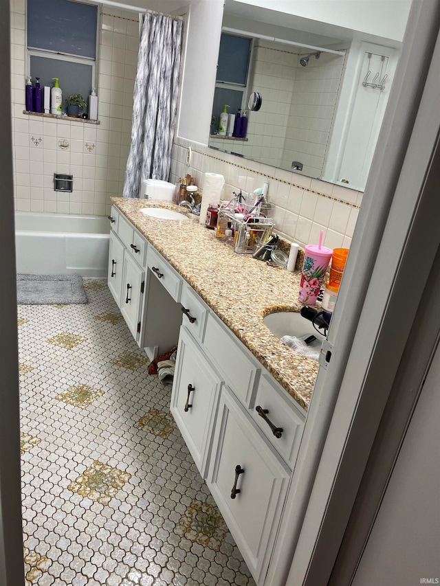 bathroom featuring shower / bath combo with shower curtain, tile patterned floors, vanity, and tasteful backsplash