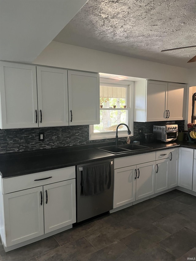 kitchen featuring a textured ceiling, white cabinetry, dishwasher, and sink