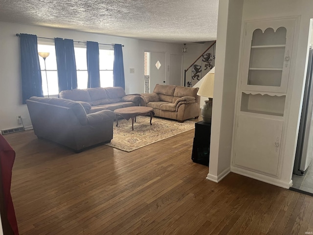 living room featuring dark wood-type flooring and a textured ceiling