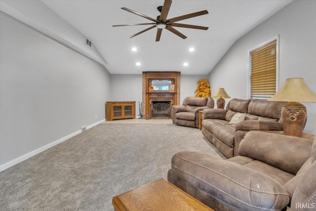 living room featuring lofted ceiling, light carpet, a fireplace, and ceiling fan