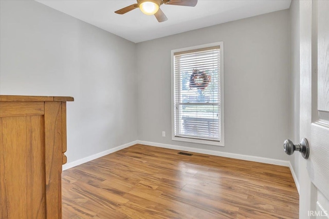 empty room with light hardwood / wood-style flooring and ceiling fan